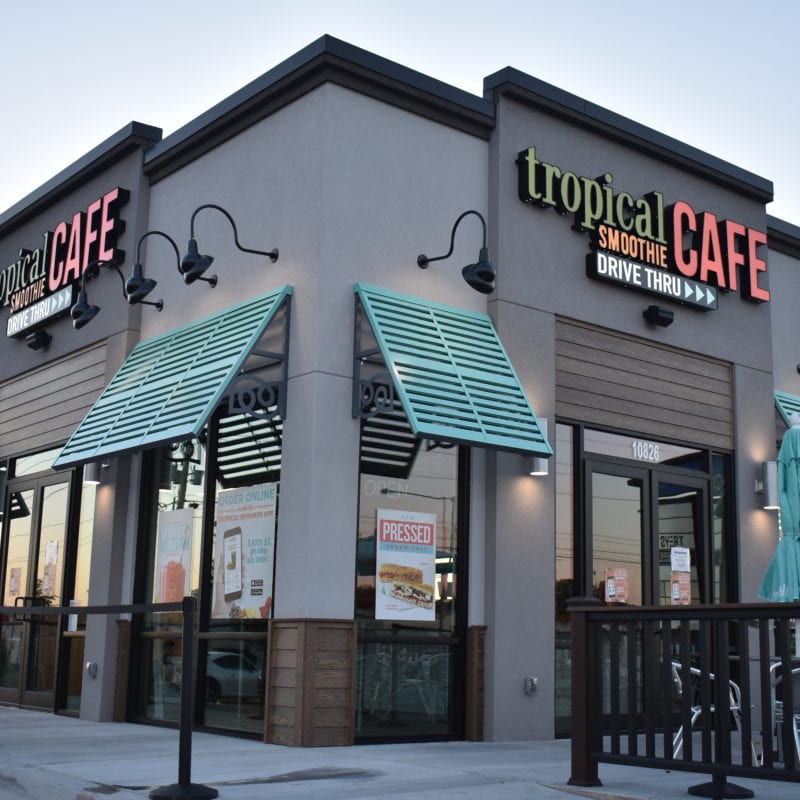 Tropical smoothie cafe location, gray building with blue awnings