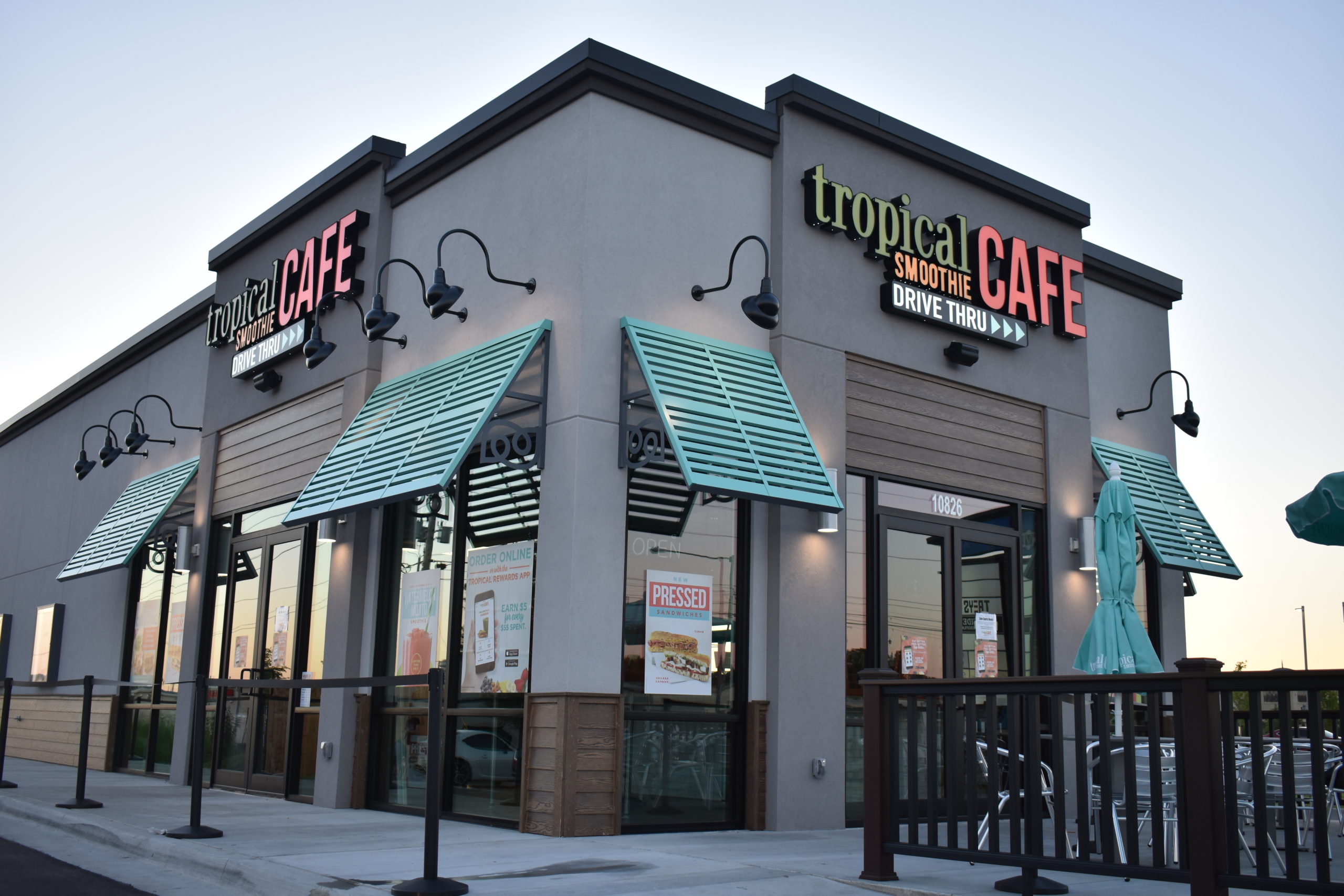 Tropical smoothie cafe location, gray building with blue awnings