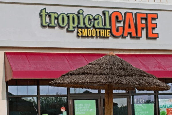 Exterior of Tropical smoothie location with umbrella in front.