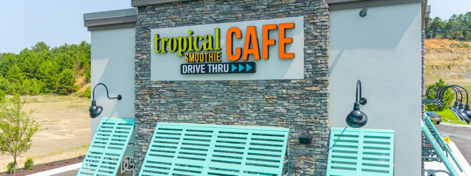 Exterior of Tropical Smoothie Cafe building with teal awnings and logo