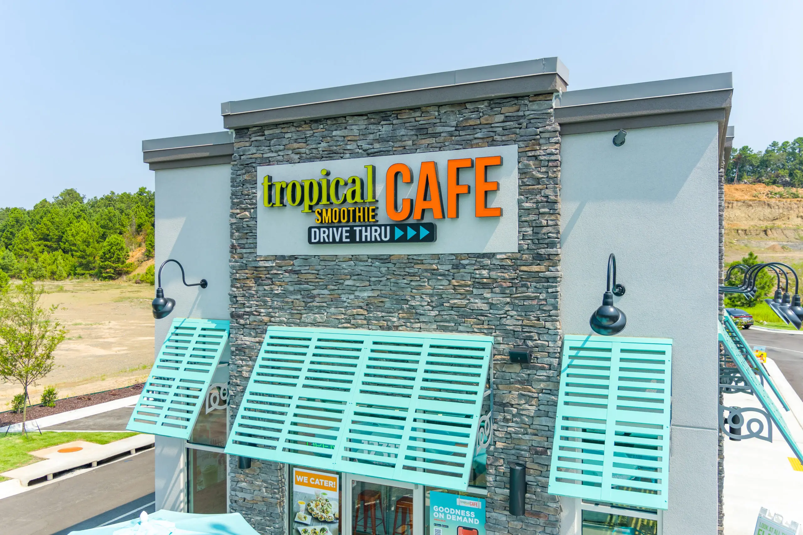 Exterior of Tropical Smoothie Cafe building with teal awnings and logo