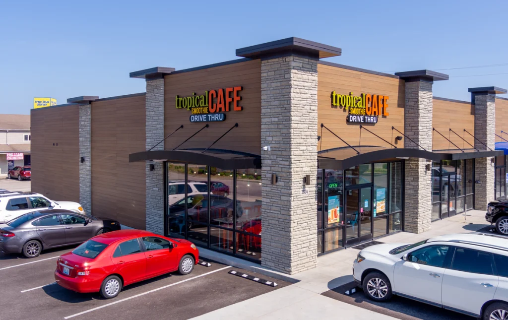 exterior of tropical smoothie cafe location on a corner with cars parked out front