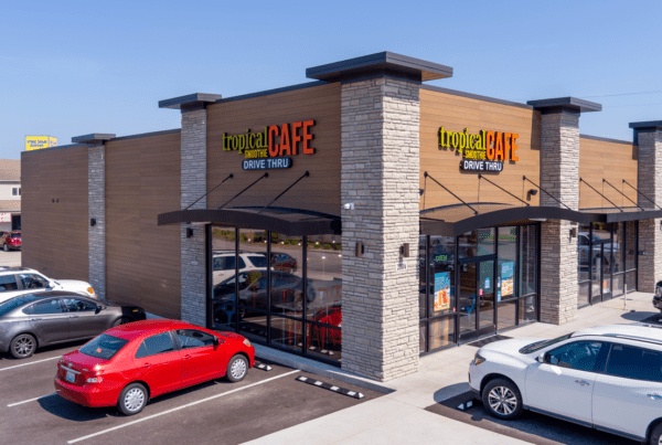 exterior of tropical smoothie cafe location on a corner with cars parked out front